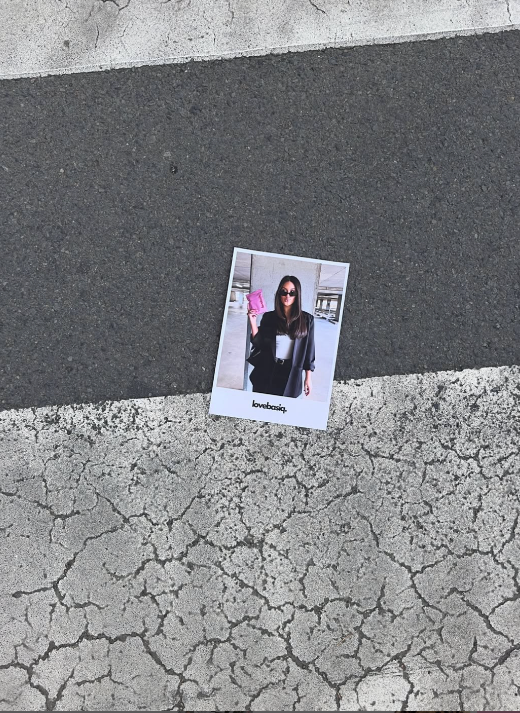 Polaroid-style photo of a person on a cracked pavement